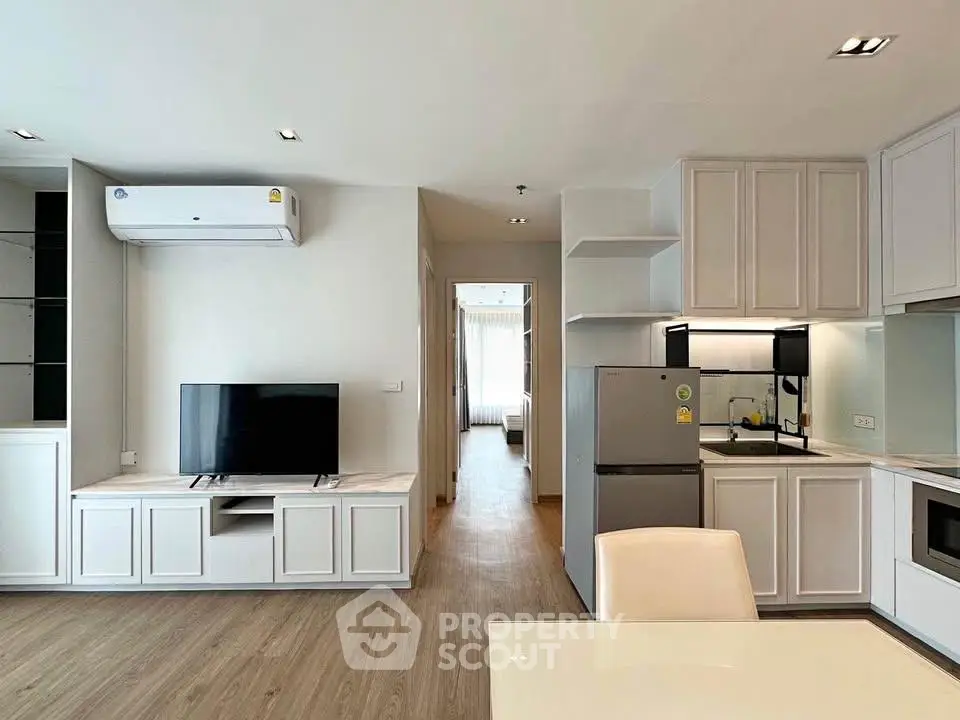 Modern open-plan living room with kitchen featuring sleek appliances and stylish decor.