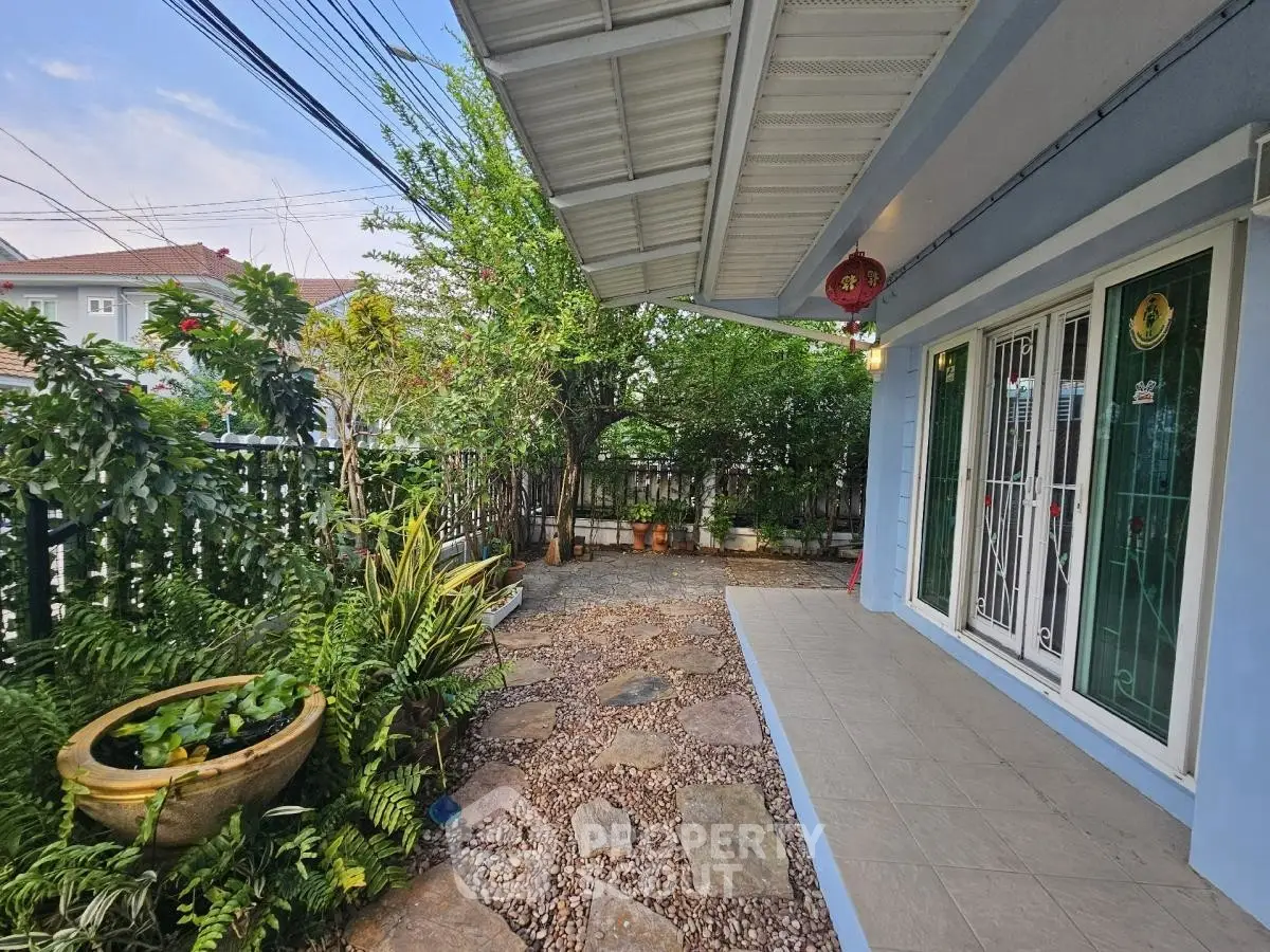 Charming home exterior with lush garden and spacious patio, perfect for outdoor relaxation.