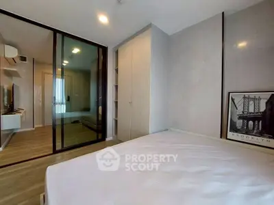 Modern bedroom with sleek design and glass partition, featuring built-in wardrobe and stylish decor.