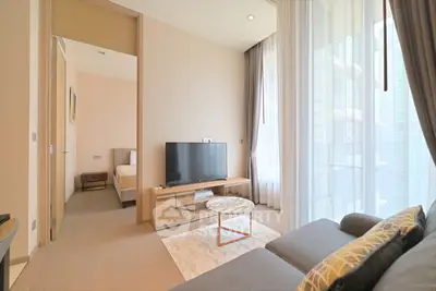 Modern living room with large windows and stylish furniture in a high-rise apartment.