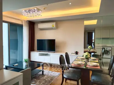 Modern living room with dining area, TV, and balcony access in stylish apartment.