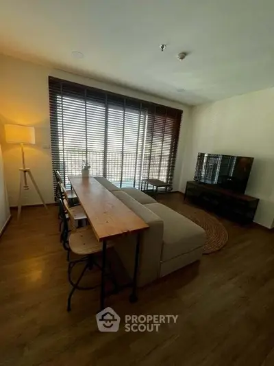Stylish living room with cozy sofa, wooden floor, and large window for natural light.