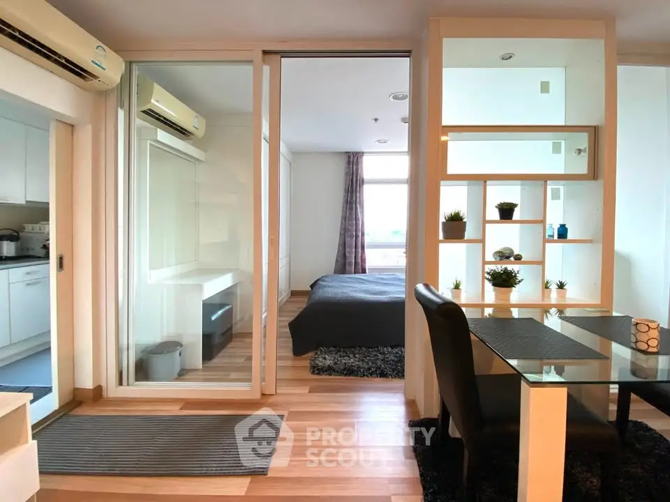 Modern studio apartment with glass partition, cozy bedroom, and stylish dining area.