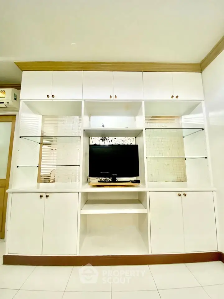 Modern living room with built-in white cabinetry and TV setup