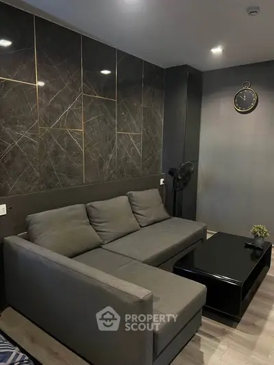 Modern living room with sleek gray sofa and stylish wall design