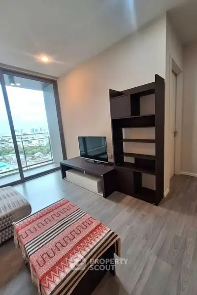 Modern living room with city view, featuring sleek furniture and large windows for natural light.