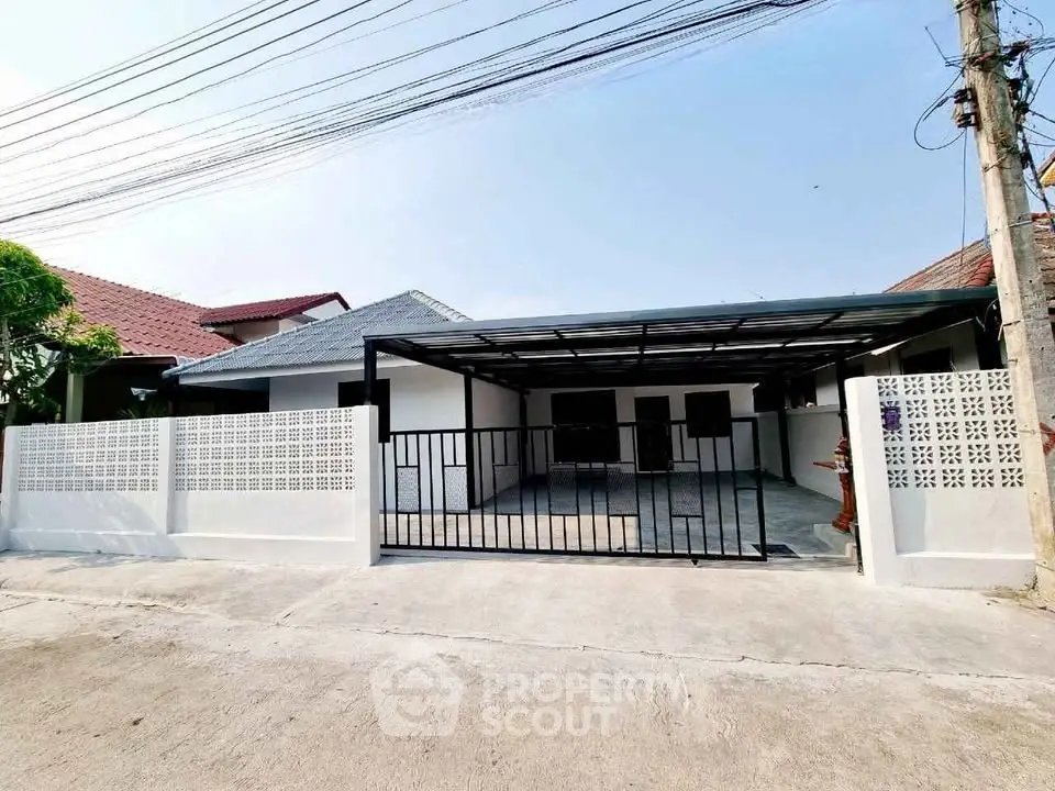 Charming single-story home with gated driveway and modern exterior design.