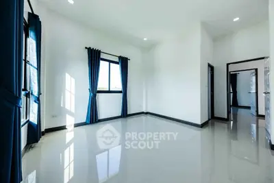 Spacious and bright empty room with large windows and glossy tiled floors, perfect for customization.