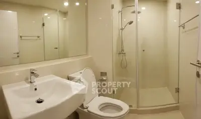 Modern bathroom with glass shower and sleek fixtures in a contemporary home.