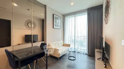 Modern living room with stylish decor and large window offering city views.