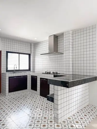 Modern kitchen with stylish tiled walls and floor, featuring a sleek gas stove and ample counter space.