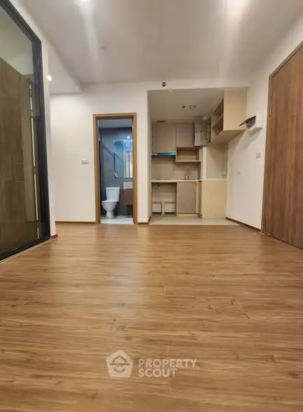 Spacious open-plan living area with wooden flooring and modern kitchen