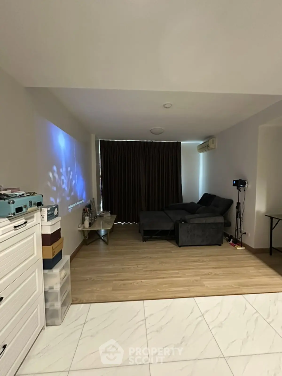 Spacious living room with modern decor and cozy seating area, perfect for relaxation.