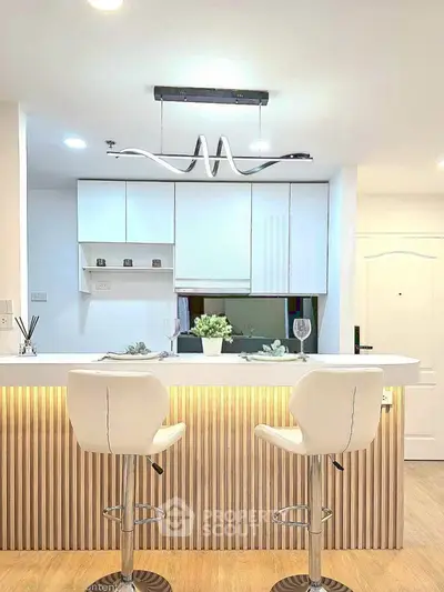 Modern kitchen with stylish breakfast bar and elegant lighting in a contemporary apartment.