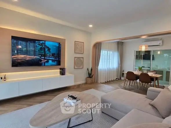 Modern living room with sleek furniture and open dining area, perfect for stylish living.