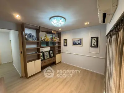 Elegant living room with modern decor and stylish lighting, featuring a built-in shelving unit and framed artwork.