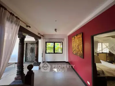 Spacious living area with traditional wooden accents and vibrant red wall
