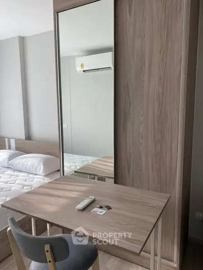 Modern bedroom with sleek wooden furniture and air conditioning, perfect for comfort and style.