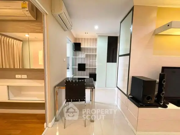 Modern apartment interior with sleek furniture and built-in storage solutions.
