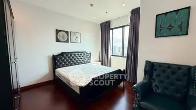 Elegant bedroom with city view, featuring a luxurious bed and stylish armchair, perfect for urban living.