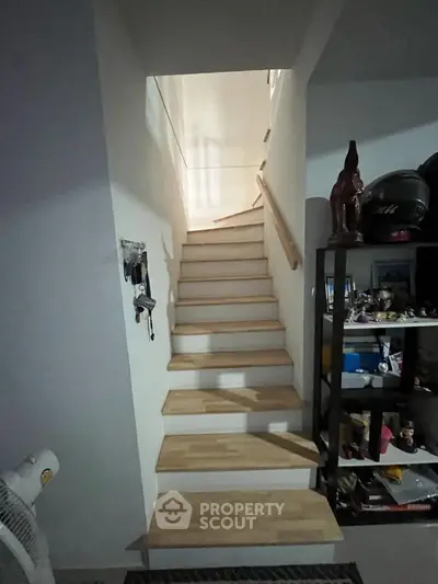 Cozy interior staircase with wooden steps and storage shelves, perfect for compact living spaces.