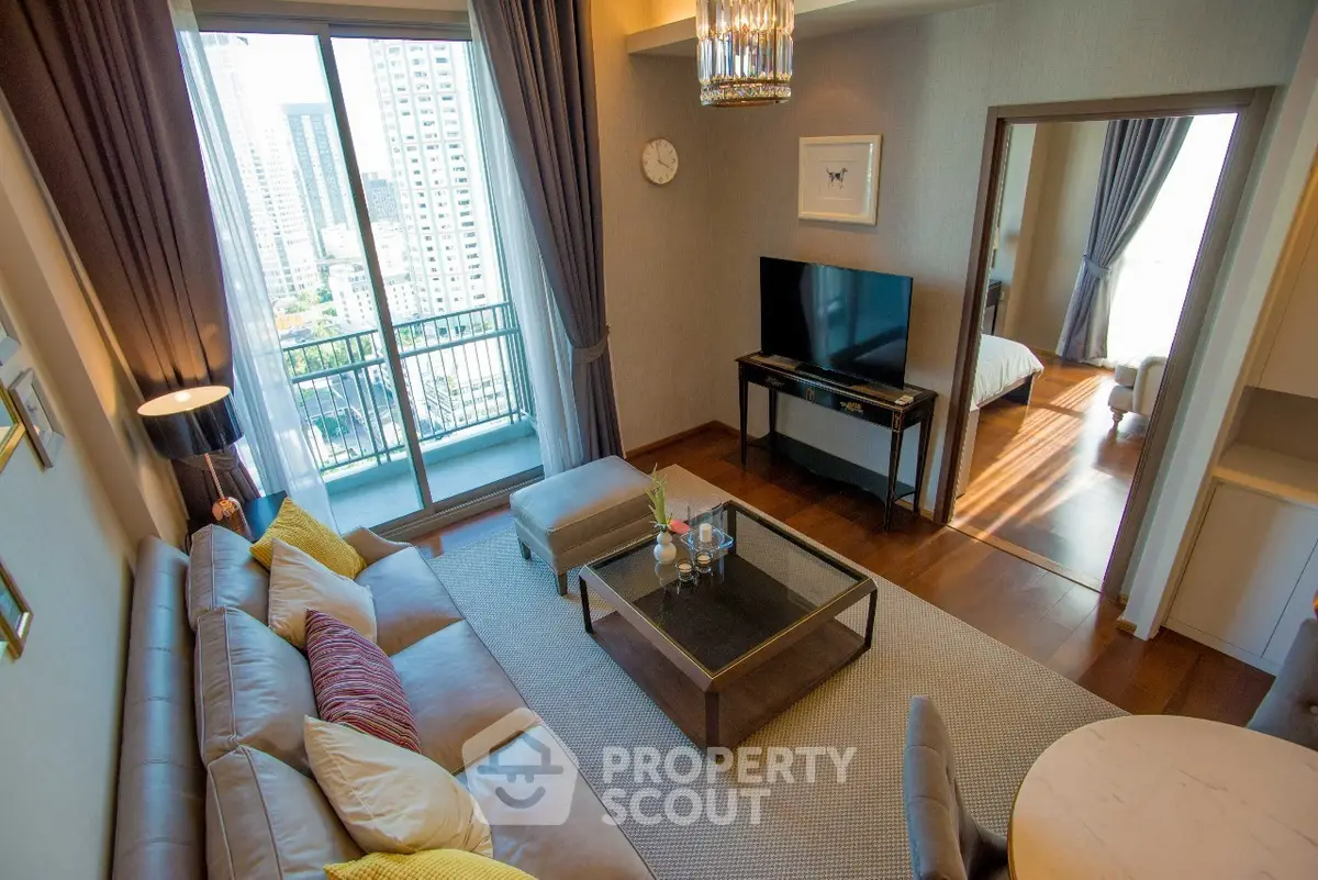 Luxurious living room with modern decor and city view balcony in high-rise apartment.