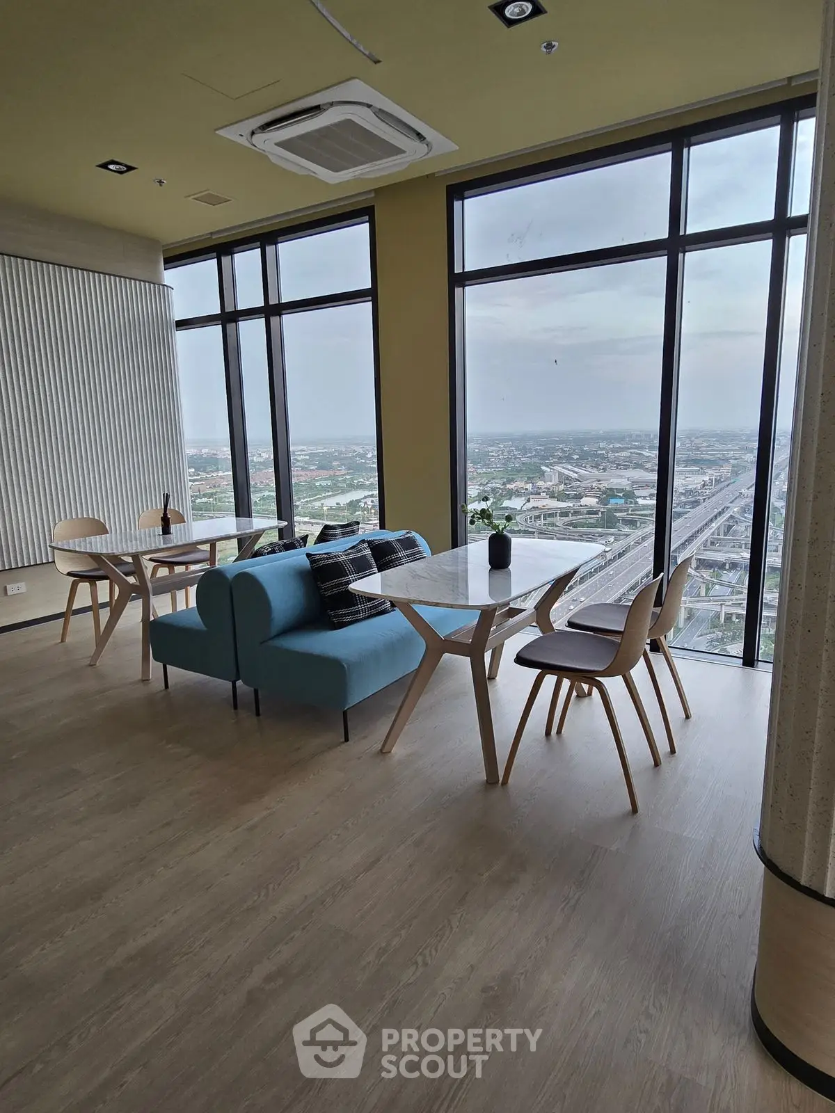 Modern high-rise apartment with panoramic city views and stylish interior design.