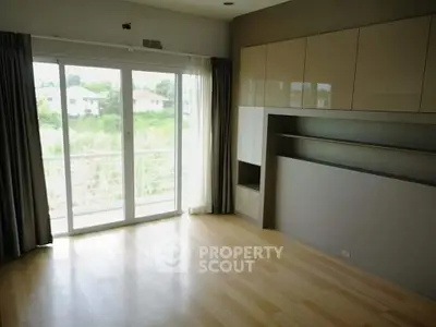 Spacious room with large windows and built-in cabinets overlooking a serene view.