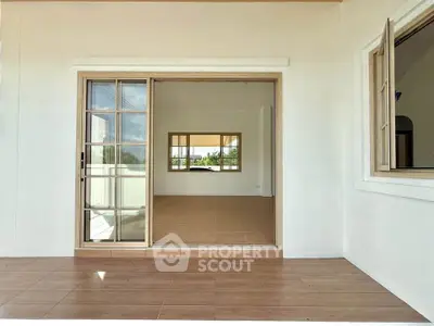 Spacious open-plan living area with sliding glass doors and tiled flooring, perfect for modern living.