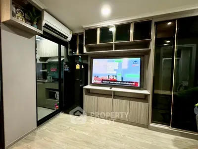 Modern living room with built-in TV unit and glass sliding doors to kitchen