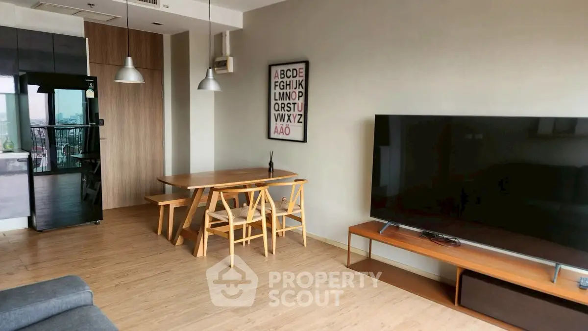 Modern living room with sleek furniture and large TV, open layout with dining area, and stylish decor.