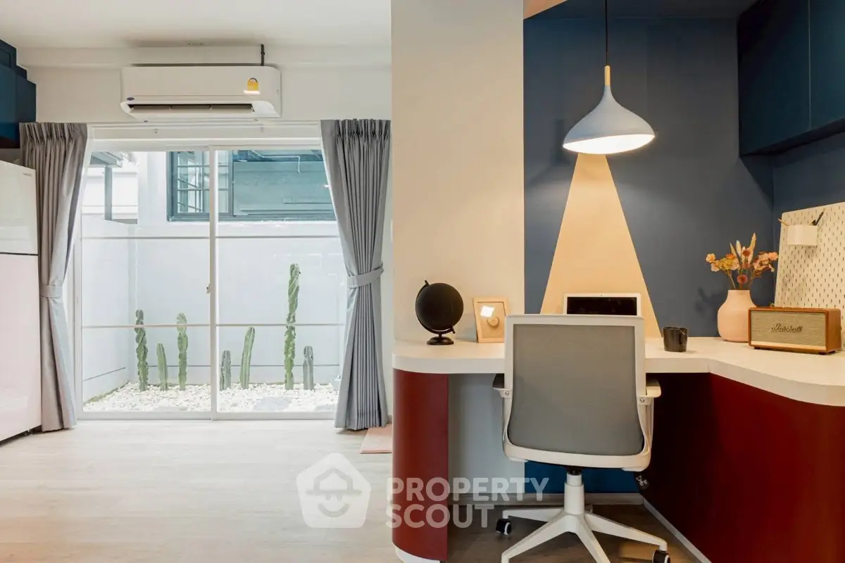 Modern home office with stylish desk and chair, large window view, and elegant lighting.