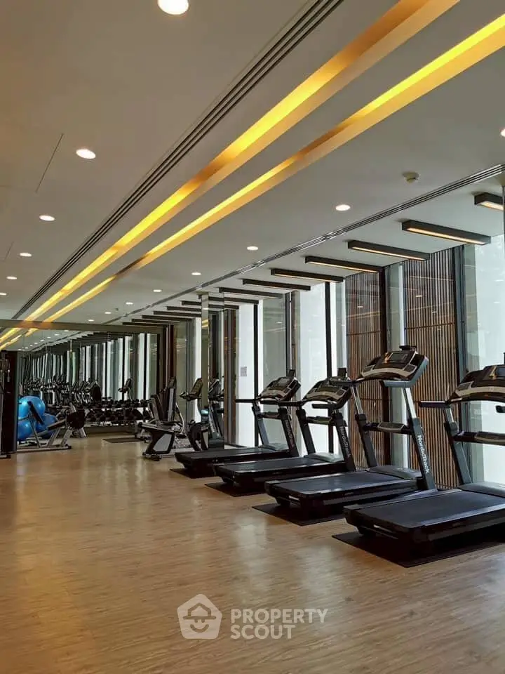 Luxurious gym with modern treadmills and sleek design in upscale residential building.