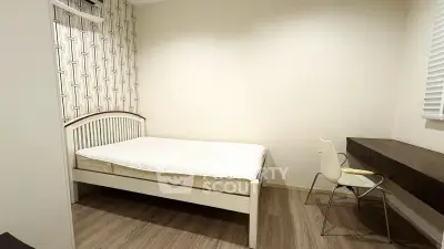 Cozy bedroom with modern decor and study area, perfect for urban living.