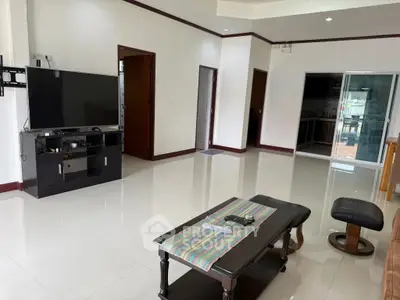 Spacious living room with modern TV setup and sleek furniture