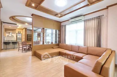 Spacious living room with modern open kitchen and elegant wooden accents