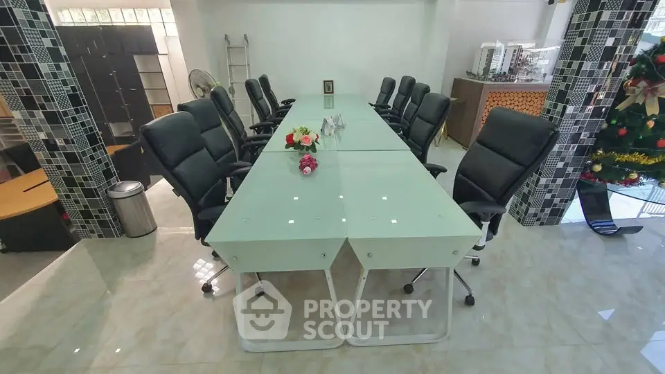 Spacious modern conference room with sleek glass table and executive chairs, ideal for professional meetings.