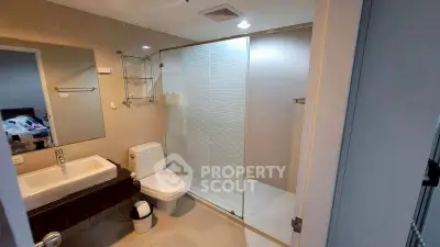 Modern bathroom with glass shower and sleek fixtures in a contemporary apartment.
