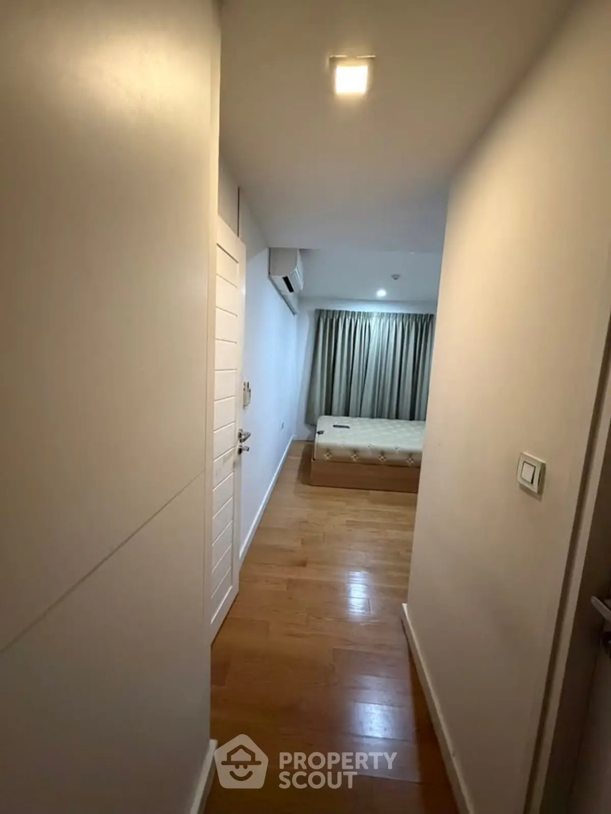 Cozy bedroom with wooden flooring and natural light