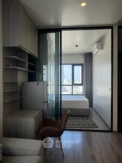 Modern apartment with open layout and city view, featuring sleek furniture and ample natural light.