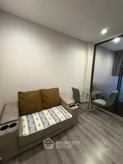Cozy living room with modern furniture and glass dining table, perfect for relaxation and entertaining.