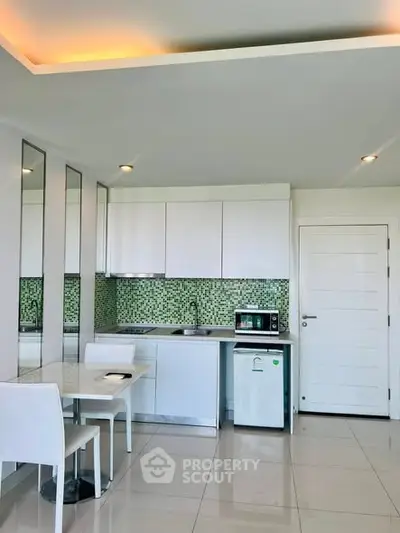 Modern kitchen with sleek white cabinets and mosaic backsplash