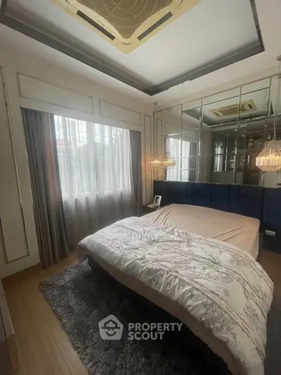 Luxurious bedroom with elegant decor and large window for natural light.
