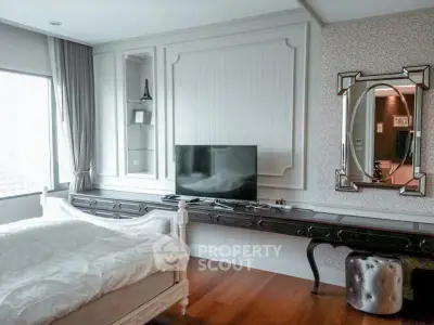 Luxurious bedroom with elegant decor and large window offering natural light.