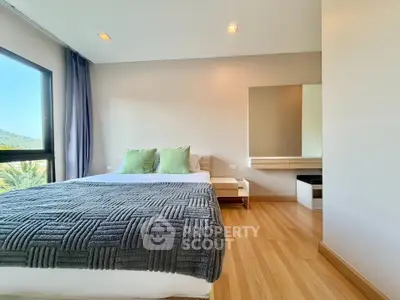 Modern bedroom with large window and stylish decor in a serene setting.