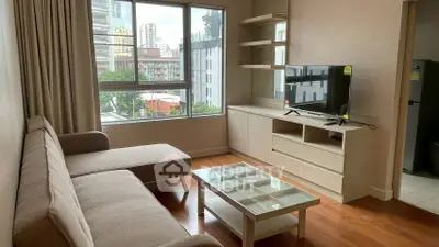 Modern living room with city view, featuring cozy sofa and sleek TV unit.