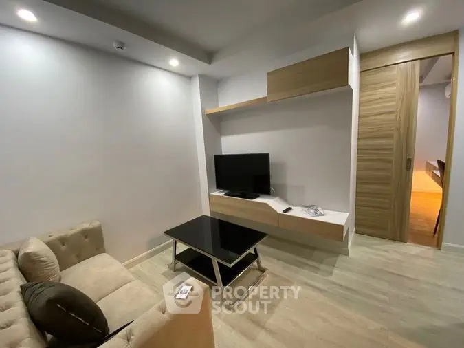 Modern living room with sleek furniture and wall-mounted TV in a stylish apartment.