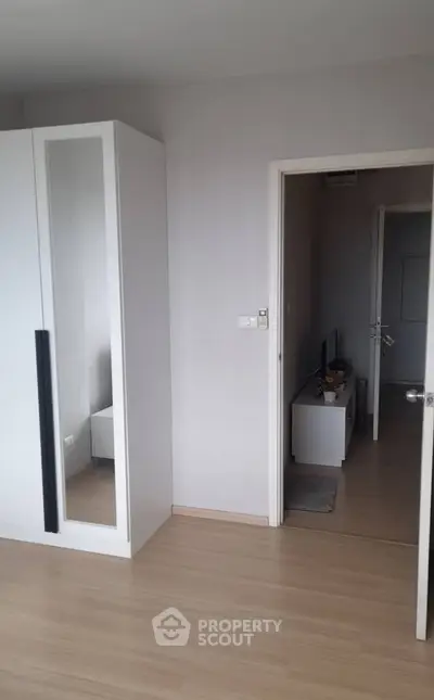 Modern bedroom with sleek wardrobe and minimalist decor in a stylish apartment.
