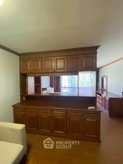 Spacious living area with elegant wooden cabinetry and open layout design