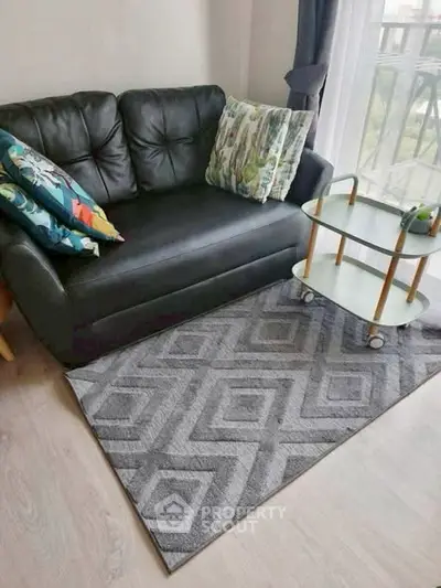 Cozy living room with stylish black sofa and geometric rug, perfect for modern urban living.